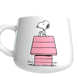 Taza de cerámica blanca con Snoopy sobre una casa rosa.