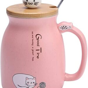 Taza rosada de cerámica con diseño de gato y cucharita de acero inoxidable.