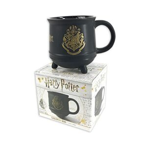 Taza negra de cerámica con diseño de caldero y escudo dorado de Harry Potter.