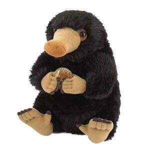 Peluche de Niffler negro y suave sosteniendo una moneda dorada.