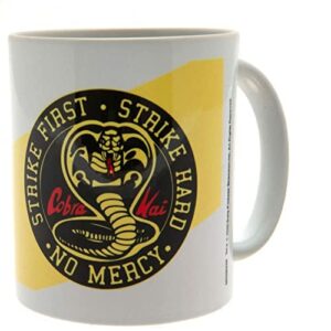 Taza de cerámica Cobra Kai con el lema "Strike First, Strike Hard, No Mercy" y el logo de la cobra.