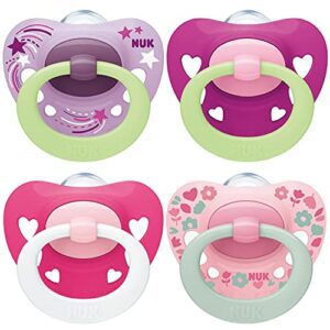 Chupetes NUK rosa y morado con diseños de estrellas y corazones, set de 4 piezas.